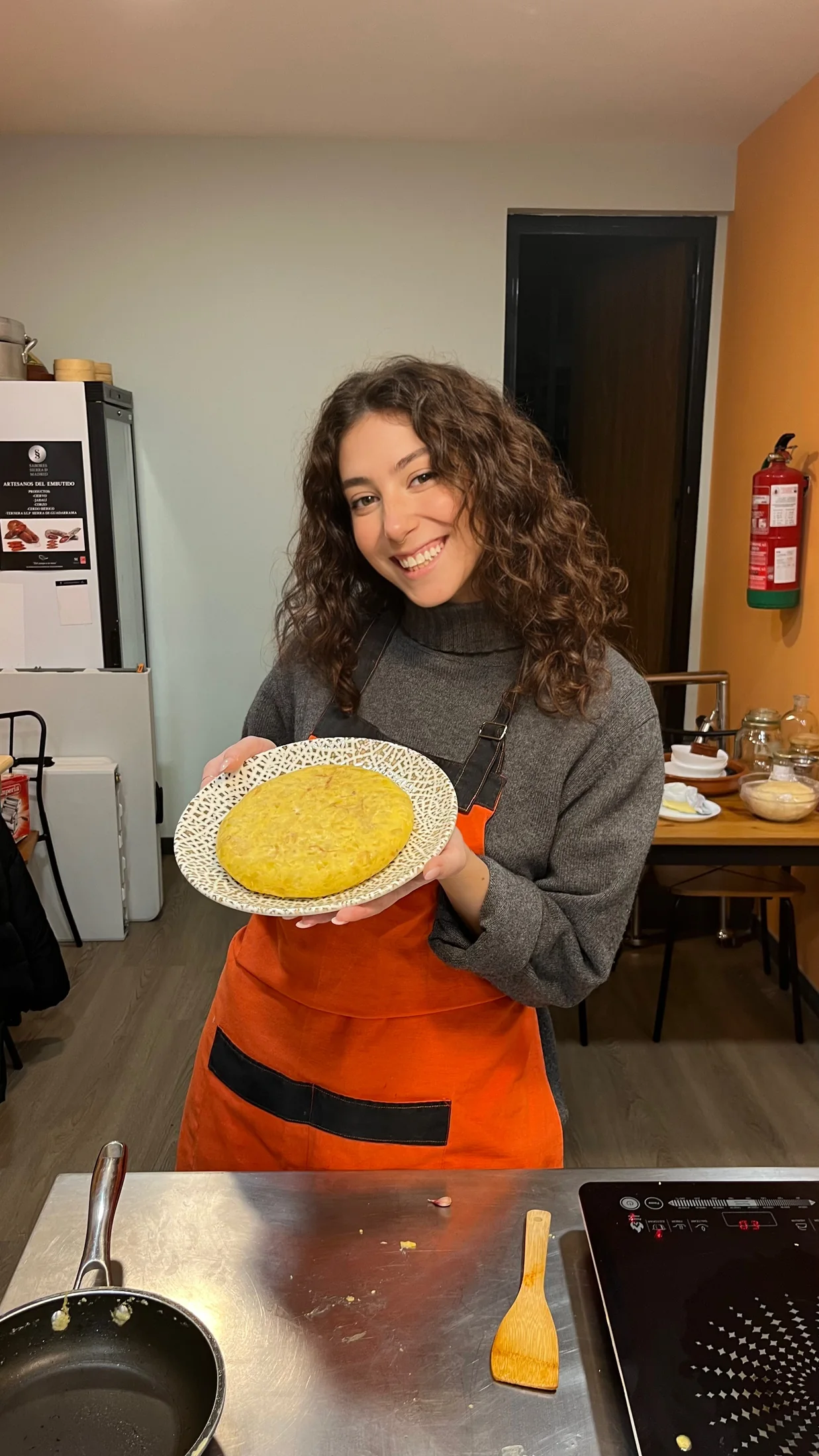 Ginevra holding a plate of semolina gnocchi in her kitchen