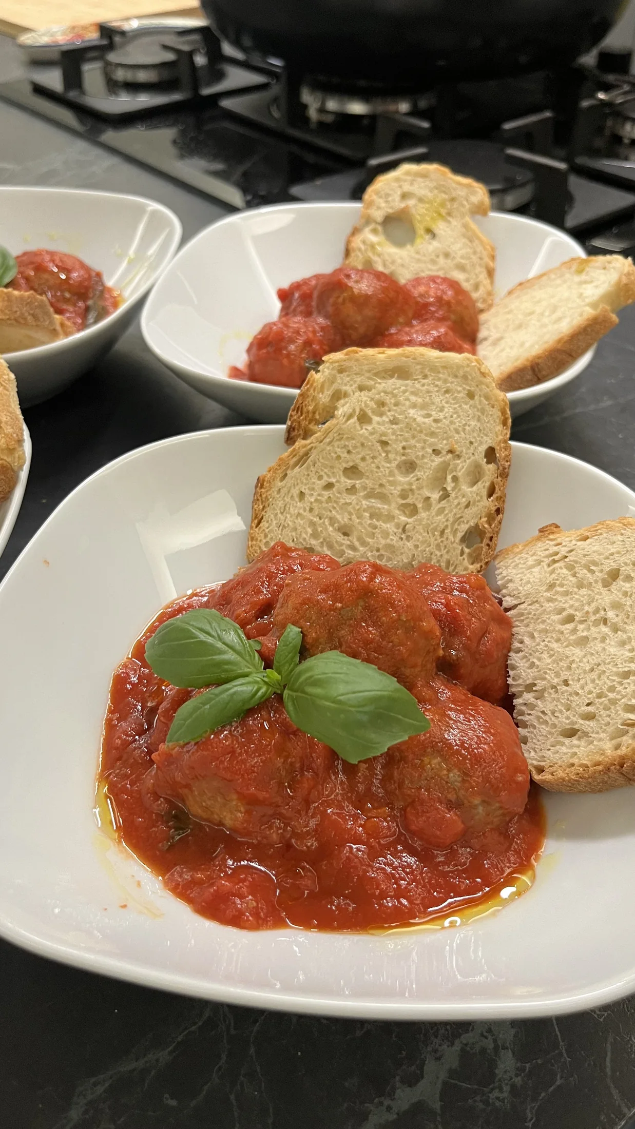 Meatballs in tomato sauce with bread and basil